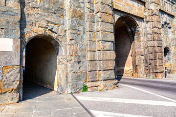 Wall Mural - Entrance to the old fortress in the city of Bergamo, Italy. stone archway is a beautiful and historic feature of the city. The archway is made of stone and has a unique design