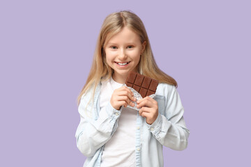 Wall Mural - Happy little girl with sweet chocolate bar on lilac background