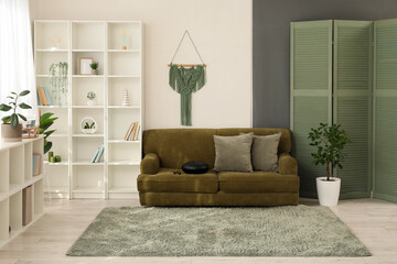 Sticker - Interior of living room with glucophone on green sofa and shelf units