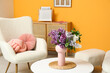 © Pixel-Shot - Interior of living room with bouquet of lilacs branches on coffee table and white armchair