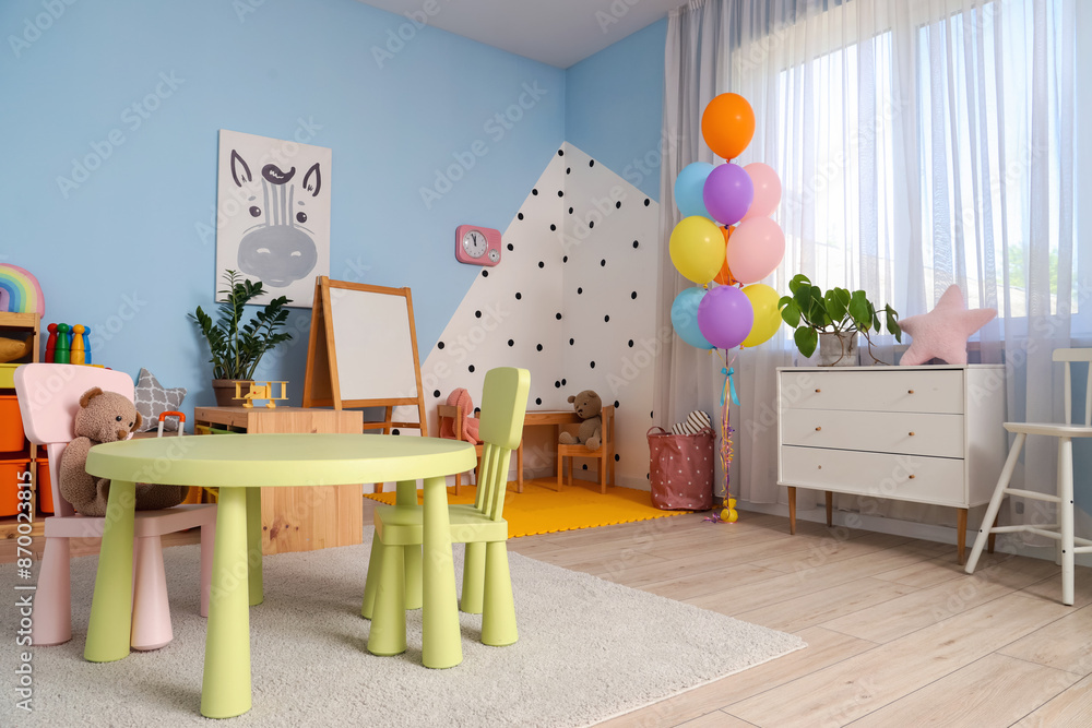 Table and chairs with teddy bear in playroom