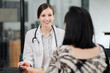 © Satori Studio - A friendly female doctor consulting with a patient in a modern medical office, providing professional healthcare services and medical advice.