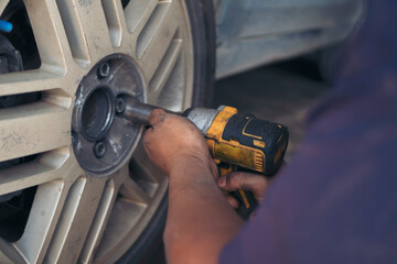 Wall Mural - Mechanic man hands checking car tires outdoor on site service auto garage for automotive mobile center services. Technician workshop repair checking tyres car motor vehicles service mechanical hands