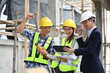 © Prathankarnpap - Construction workers in safety helmets celebrating a successful project on construction site