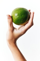 Poster - Person holding a green lime on a white background, isolated from the rest of the image