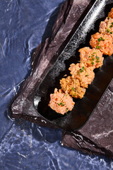 Canvas Print - Spicy Sushi Set on Black Plate with Water Ripples Background - Vibrant Food Photography