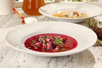 Wall Mural - Refreshing Summer Beet Soup (Свекольник) in Sunlit White Bowl on Wooden Surface