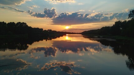 Wall Mural - The sight of a sunset over a river, the water reflecting the colors and creating a mirror image, brings a sense of calm and beauty.