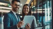© yj - Two happy professional male and female business people team working using digital tablet tech discussing financial market data standing at corporate office meeting.