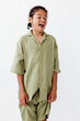 © SHOTPRIME STUDIO - joyful young boy dressed in green clothing exudes happiness in front of minimalist white backdrop