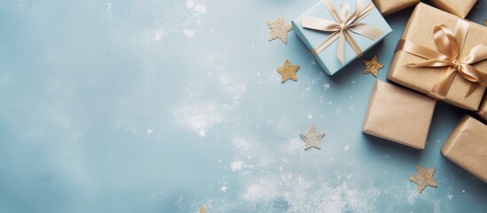 Wall Mural - Craft paper-wrapped Christmas gifts on a textured light blue backdrop, suitable for postcards or invitations, featuring a top view with copy space image.