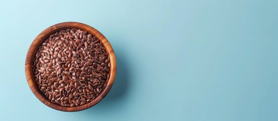 Leinwandbilder - Brown flax seeds in wooden bowl Isolated on pastel background. with copy space image. Place for adding text or design