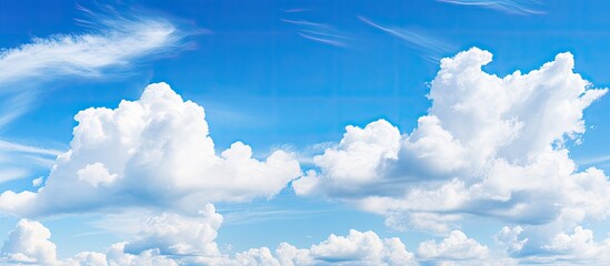 Copy space image of a serene nature backdrop with blue skies and fluffy white clouds in a horizontal layout.