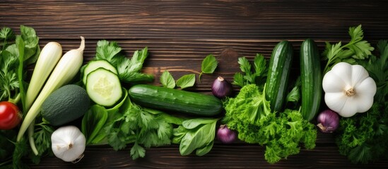 Aufkleber - Top view of various fresh seasonal vegetables like cucumbers, white eggplants, fennel, basil, and kale leaves on a wooden table with copy space image.