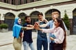 © master1305 - Caucasian, Arabian, Indian, and Muslim people, multiracial students standing outside the university and interacting, preparing for common project. Concept of education, multicultural students, unity