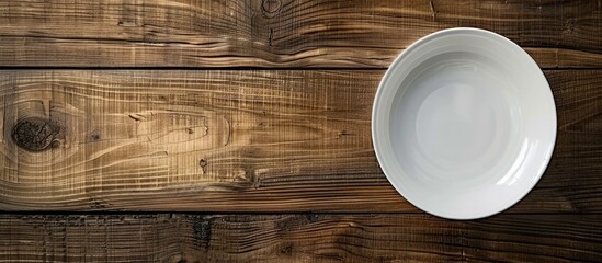 Wall Mural - Wooden table with a white plate, showcasing a copy space image.