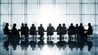 © Awut - Silhouettes of business professionals gathered for a meeting, discussing strategies at a large conference table in a bright modern office.