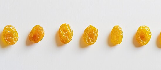Wall Mural - A line-up of yellow raisins set against a plain white backdrop, with an empty space for text or other illustrations, known as copy space image.