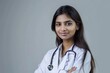 © darshika - Indian female doctor in white coat with stethoscope smiling.