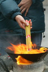 Lama Temple in Beijing. Prayer time. Woman with incense. China.