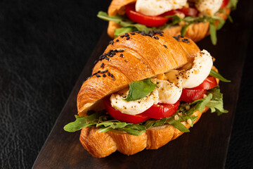 Wall Mural - Italian food snack. Fresh croissant caprese, mozzarella, arugula and tomatoes