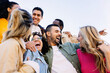© Xavier Lorenzo - Young group of people having fun together outdoors in a sunny day. Multiracial best friends laughing outside. United millennial students enjoying time. Friendship concept.