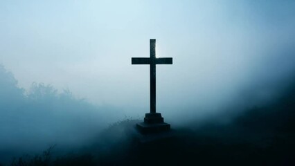 Wall Mural - Religious cross on a mountain in a foggy landscape. Silhouette of cross on mountain moody fog mystery dark