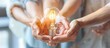 © Grigor - Teamwork, People's hands help each other to hold light bulbs. Success of unity.