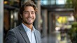 © Tetiana - A young man in a suit stands outside, looking directly at the camera with a friendly smile