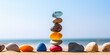 © Aksana - Balanced stack of colorful stones on a beach, pebble concept