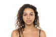© vladimirfloyd - portrait of a young serious woman with curly hair and without makeup on a white background