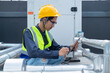 © Washburn - Engineer checks valves, water tanks, pumps and equipment related to hot water production pipe systems.