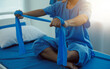 © Sirikarn Rinruesee - Close up hand patient doing stretching exercise with a flexible exercise band and a physical therapist hand to help in clinic room.