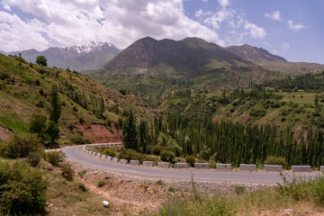 A mountain range with a winding road that leads to the top