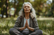 © Dennis - A senior woman meditating in nature with headphones on, guided meditation, and mindfulness app concept