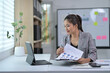 © Parichat - Businesswoman Analyzing Financial Charts on Tablet in Modern Office Setting