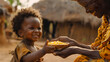 © catocala - Young african child, with curly hair, stands in front of an older woman who is feeding them a plate of corn. Both are smiling and the image is taken in a rural African village.