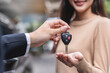 © Pormezz - transportation rental automotive business concept. Close up hands of rental auto agent giving car remote key to client to travel sightseeing.