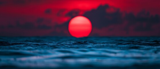 Wall Mural -  Red sun sets over ocean, middle bearing dark clouds, background shrouded in darkness