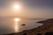 © Artaxerxes - The alone fishing boat on the water of Dead Sea close to Israel coast (Ein Gedi) during the colorful sunset in the Middle East.