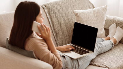 Wall Mural - Multitasking. Student Girl Working on Laptop and Talking on Phone at Home, Copy Space