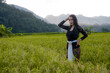 © syafiul - a beautiful Indonesian woman wearing a black Balinese kebaya with a background of rice fields and mountains