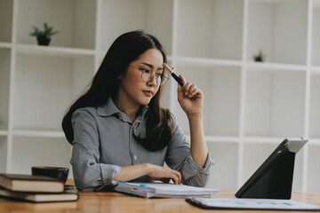 Wall Mural - Portrait of Asian young female working on laptop and financial report at office.