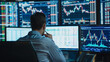 © Anastasiia - А stock brokerworking with graphs on monitors, surrounded by numbers and financial reports, stock charts on the screen, stylish business environment