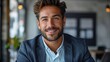 © Pinklife - A businessman is engaged and smiling in a formal setting, exuding confidence and professionalism. The corporate environment and modern attire complement his approachable demeanor.