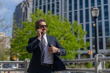 Canvas Print - Middle aged Hispanic businessman with phone. Business communication. Business man having phone call outdoor. Businessman using phone. Man phone conversation in suit. Banner