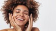 © MD Media - Skincare editorial shoot of a blonde woman with hands on face in front of a beige background. Smiling Woman Touching Neck. Waist up Portrait of Attractive Woman Touching her Skin.
