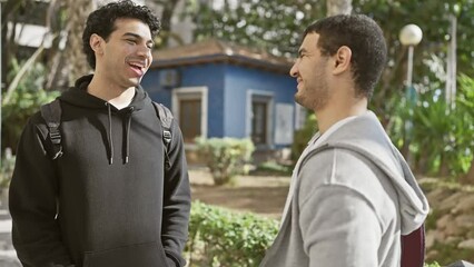 Sticker - Two smiling men converse in a leafy urban park, showcasing friendship and casual urban lifestyle outdoors.