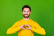 © deagreez - Photo of cheerful handsome man with stylish beard dressed yellow shirt fingers showing heart symbol isolated on green color background