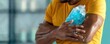 © wanavit - Man applying an ice pack to his injured elbow, wearing a yellow shirt. Healthcare concept, injury recovery, and pain relief treatment.